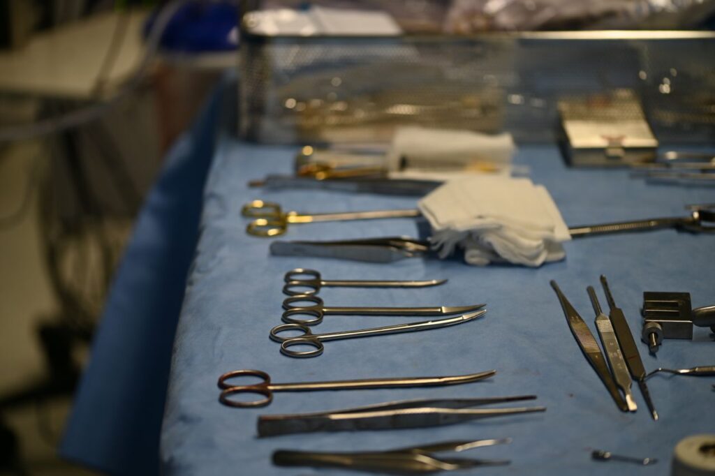 A close-up of various surgical tools neatly arranged on a sterile blue table in a hospital setting.